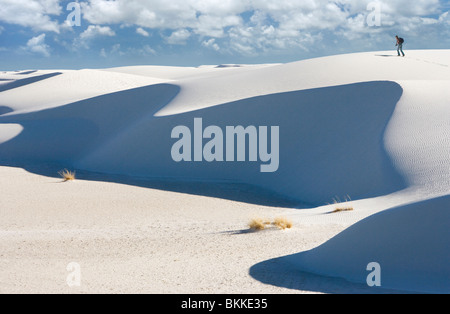 Eine Person, die zu Fuß, eine große weiße Sanddüne in White Sands National Monument, New Mexico. Stockfoto