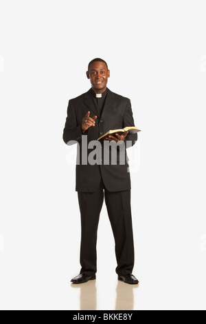 Ein Mann trägt eine klerikal-Kragen und aus der Bibel zu predigen Stockfoto