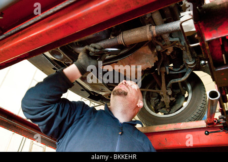 Garage Mechaniker überprüfen die Unterseite eines Autos während einer TÜV-Prüfung im Vereinigten Königreich Stockfoto