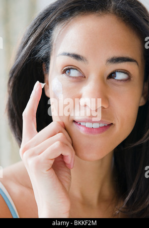 Gemischte Rassen Frau eincremen Stockfoto