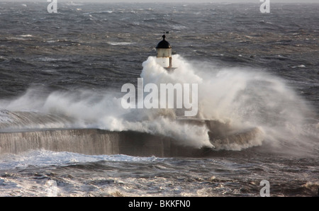 Seaham, Teesside, England; Wellen, die auf einem Leuchtturm im Ozean Stockfoto