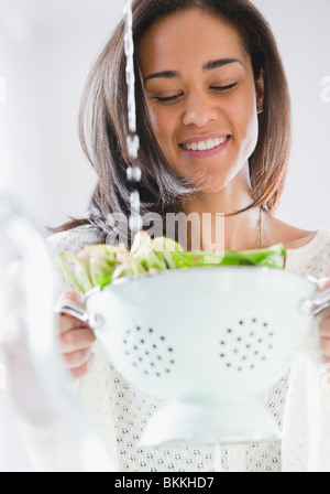 Gemischte Rassen Frau Spülen Spinat Stockfoto