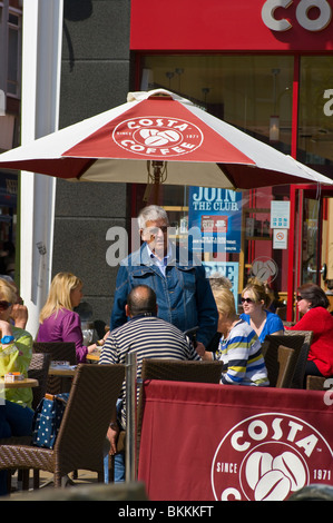 Menschen entspannen zusammen am Tische draußen ein Costa-Kaffee Stockfoto