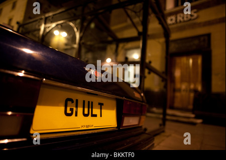 Bentley Auto mit dem Nummernschild G1 ULT ("Schuld" falsch geschrieben) in der Nacht außerhalb der Royal Bank of Scotland Stockfoto