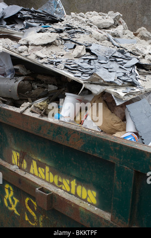 Bauschutt-Arbeit in einem Müllcontainer warten auf Entfernung, mit kein Asbest-Schild an der Skip - UK Europe Stockfoto