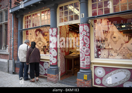 Menschen suchen am Fenster eines Spitzen-Shops in Brügge, Belgien Stockfoto