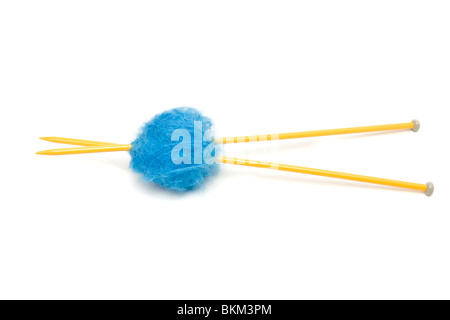 Eine kleine Kugel aus blauem Mohairwolle durchbohrt mit großen gelben Stricknadeln gegen weiß. Stockfoto
