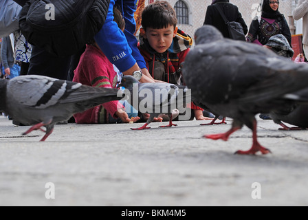 Kinder spielen mit Tauben in Markusplatz entfernt, Venedig, Italien Stockfoto