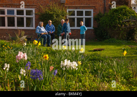 Ein MODEL Release Bild einer Familie Garten Bouleplatz in einem englischen Landhaus Cottage-Garten in Suffolk, England, Vereinigtes Königreich Stockfoto