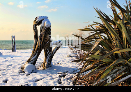 Schnee bedeckte Palme und Schnitzen in den waterwise Garten am Strand von Worthing in West Sussex, die muss nur Regen Wasser. Stockfoto