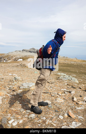 Man lehnt sich dem Wind an einem sehr windigen Tag auf exponierte Berggipfel der Glyder Fawr im Snowdonia National Park North Wales UK Stockfoto