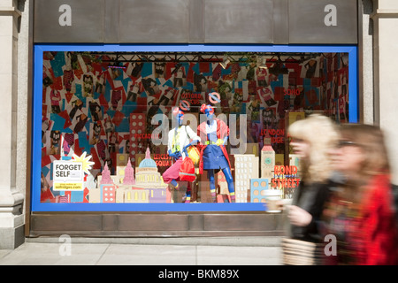 Shopper, vorbei an einem Schaufenster im Kaufhaus Selfridges, Oxford Street, London UK Stockfoto