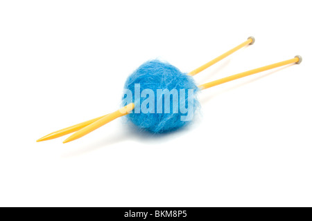 Eine kleine Kugel aus blauem Mohairwolle durchbohrt mit großen gelben Stricknadeln gegen weiß. Stockfoto