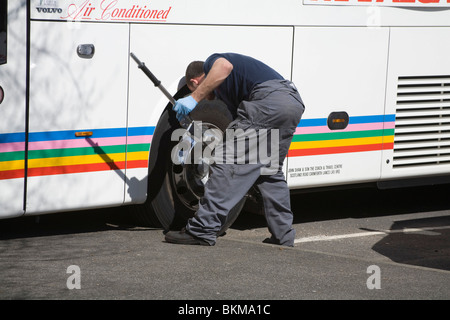 Nahaufnahme Mann anziehen der Radmuttern auf einen Reisebus Stockfoto