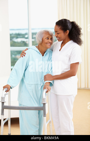 Afrikanische amerikanische Krankenschwester hilft senior Frau mit walker Stockfoto