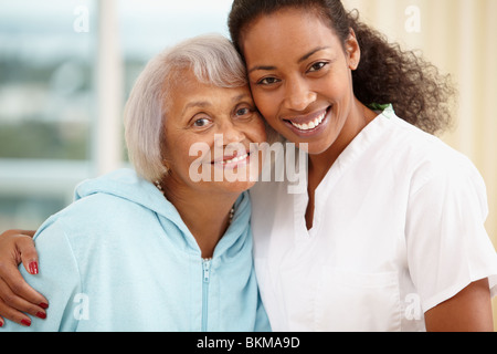 Afrikanische amerikanische Krankenschwester umarmt senior Frau Stockfoto