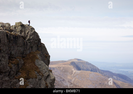 Mann steht allein auf einem schroffen Berggipfel mit Blick über. Glyder Fawr Ogwen Snowdonia National Park North Wales UK Großbritannien Stockfoto