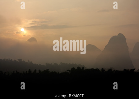 Markante Kalksteinhügel im Nebel bei Sonnenaufgang in der Nähe von Yangshuo, Region Guangxi, China Stockfoto