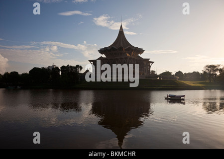 Ein Tambang (Sampan Wassertaxi) kreuzt die Sarawak River mit dem State Assembly Building über. Kuching, Sarawak, Borneo, Malaiisch Stockfoto