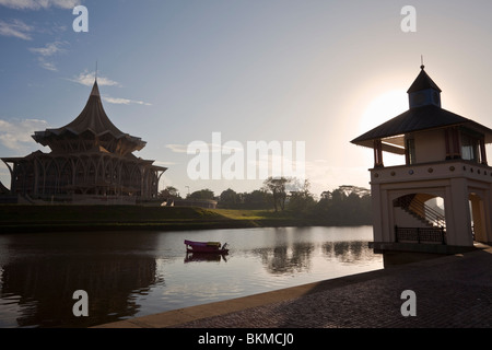 Ein Tambang (Sampan Wassertaxi) kreuzt die Sarawak River mit dem State Assembly Building über. Kuching, Sarawak, Borneo, Malaiisch Stockfoto