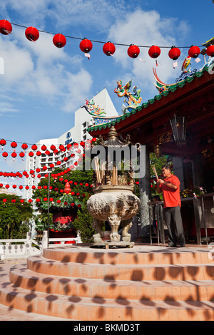 Ein Anhänger macht ein Angebot bei den Tua Pek Kong chinesischen Tempel Weihrauch. Kuching, Sarawak, Borneo, Malaysia. Stockfoto