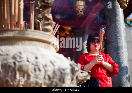 Eine Frau macht ein Angebot bei den Tua Pek Kong chinesischen Tempel Weihrauch. Kuching, Sarawak, Borneo, Malaysia. Stockfoto