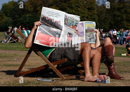 Lektüre der Sonntagszeitungen in den Kensington Gardens, London Stockfoto