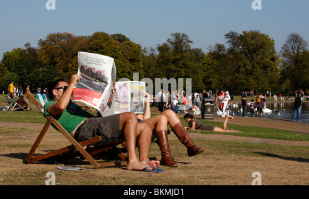 Lektüre der Sonntagszeitungen in den Kensington Gardens, London Stockfoto