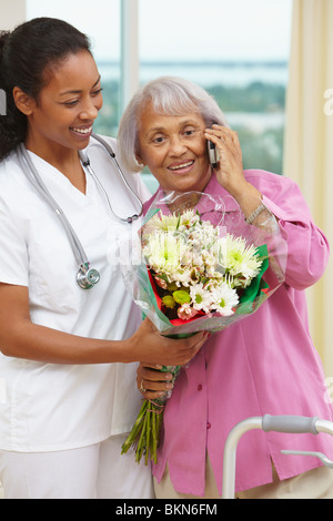 Krankenschwester helfen afroamerikanische Frau am Handy Stockfoto