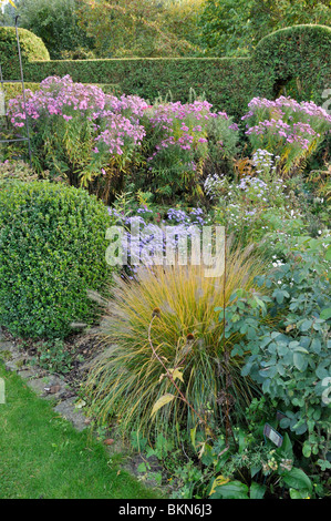 Die herbstlichen Garten mit Springbrunnen, Gras (PENNISETUM) und Astern (Aster). Design: Marianne und Detlef lüdke Stockfoto