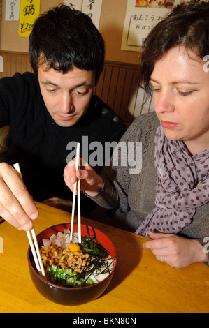 Jess und Anthony versuchen eine Schale mit Natto und verschiedenen schleimige Inhaltsstoffe Natto Restaurant, Mito, Japan Stockfoto