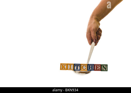 Frau mit einer Kelle hält Kinder Blöcke, die "Küche" buchstabieren Stockfoto