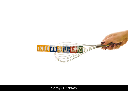 Frau mit einem Schneebesen, der Kinder hält blockiert Schreibweise "Küche" Stockfoto