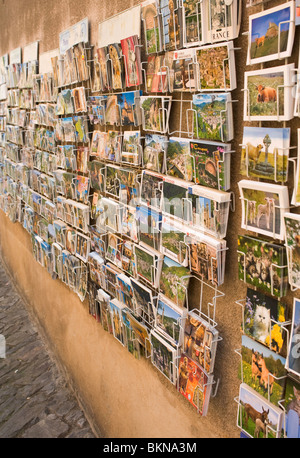 Postkarten zum Verkauf in Racks außerhalb ein Geschenkladen in Conques Aveyron Midi-Pyrenäen-Frankreich Stockfoto