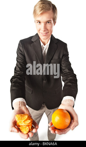 Lächelnder junge Mann bietet eine Auswahl zwischen gesunden und ungesunden Essen Stockfoto