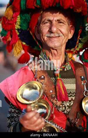 Ein Thermalwasser "Amica" Verkäufer in traditioneller Tracht auf den Märkten der Djemaa el Fna in Marrakesch, Marokko Stockfoto