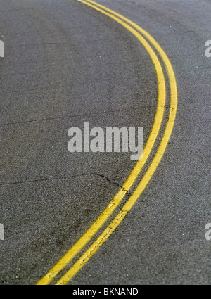 Ausführlichen schließen sich von gekrümmten doppelte gelbe Linie auf rissigen Asphalt Straße, Montana, USA Stockfoto