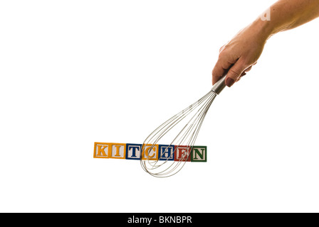 Frau mit einem Schneebesen, der Kinder hält blockiert Schreibweise "Küche" Stockfoto