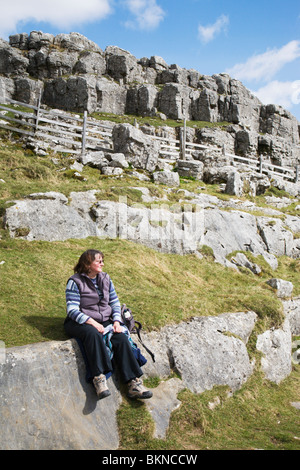 Eine Frau Walker nimmt sich eine Auszeit im oberen Bereich Malham Cove. Stockfoto