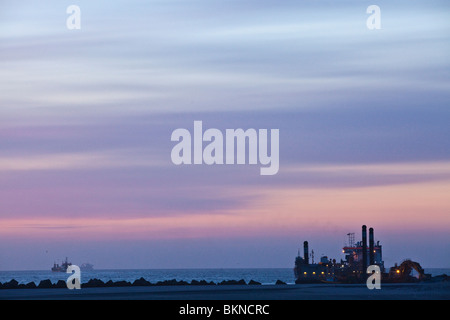 Maasvlakte 2 während der Dämmerung mit Pastell lila farbigen Abend mit nachgestellten Sauger Trichter Bagger Utrecht im Hintergrund Stockfoto