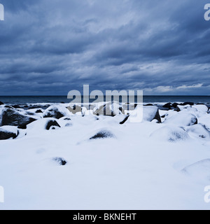 Schneebedeckte Felsen an der Küste, nahe Kvalness, Lofoten Inseln, Norwegen Stockfoto