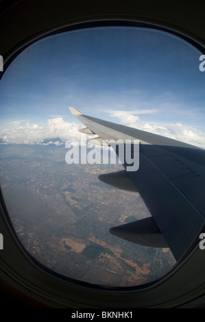 Blick vom Bullauge Boeing B747 - 400P Flügel und Land, Malaysia Stockfoto