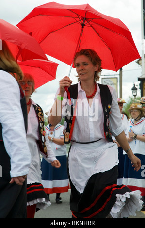 Damen Morris tanzen mit roten Sonnenschirmen auf dem Upton Folk Festival Stockfoto