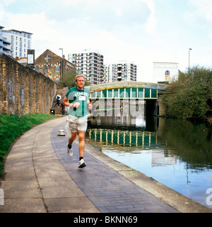 Ein Mann läuft auf dem Leinpfad der Regents Canal in der Nähe von Hoxton in East London England UK KATHY DEWITT Stockfoto