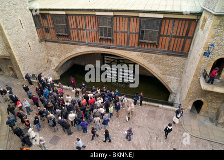 Ein Yeoman Warder oder Beefeater führt Touristen in der Nähe des Verräters Tor in den Tower of London Stockfoto