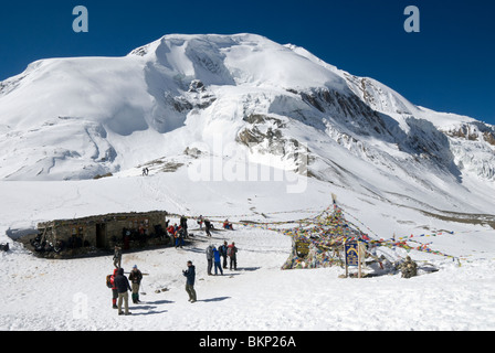 Gebetsfahnen und schneebedeckten Berge, Gipfel des Thorung La Pass (5416m), Annapurna Circuit, Nepal Stockfoto