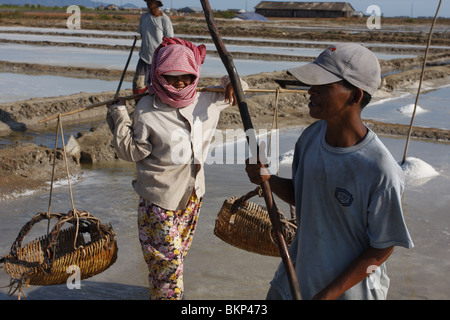 Männer und Frauen arbeiten in der glühend heißen Salz Farmen von Kampot, Kambodscha. Stockfoto