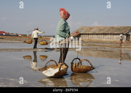 Männer und Frauen arbeiten in der glühend heißen Salz Farmen von Kampot, Kambodscha. Stockfoto