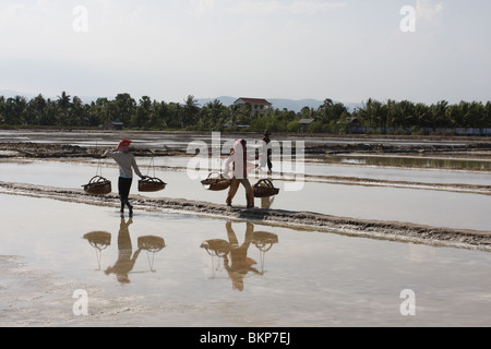 Männer und Frauen arbeiten in der glühend heißen Salz Farmen von Kampot, Kambodscha. Stockfoto