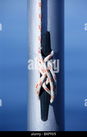 Marine Seil, Knoten nahe einem Stahlmast, blaue Wasser Hintergrund Stockfoto